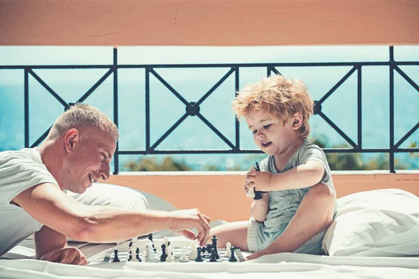 Man onderwijzen van jongen de regels van Schaken - spelen op de vloer van het balkon. — Stockfoto