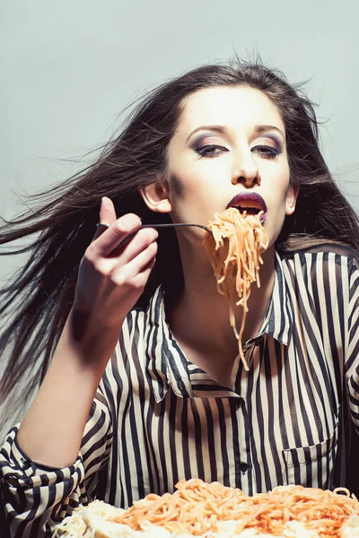 有趣的年轻漂亮的女人吃意大利面条西红柿 — 图库照片