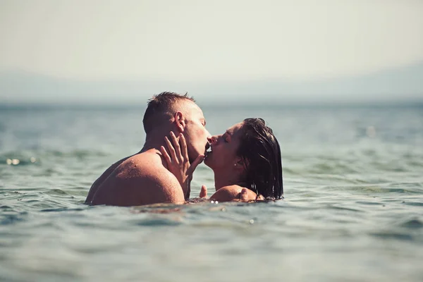 Familie en Valentijnsdag. Sexy vrouw en man zwemmen in zeewater. Zomervakantie en reizen-vakantie. Verliefde paar ontspannen op het strand. Hou van de betrekkingen van het kussen paar genieten van zomerdag samen — Stockfoto