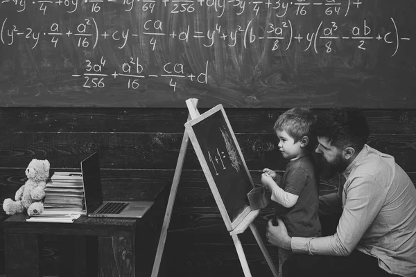 Allievo con insegnante a scuola. Vista laterale padre e figlio imparano l'aritmetica. Papà spiegando equazione per bambino carino — Foto Stock