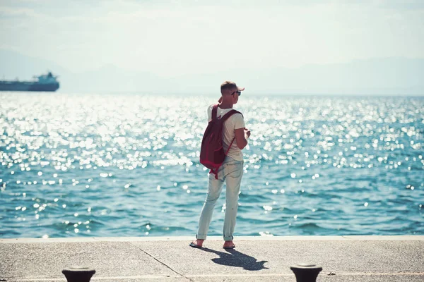 adam gezgin uzakta denizde seyir su sırt çantası ile. seyahat ve yolculuk tutkusu kavramı. yaz tatili ve maceraları. Genç adam deniz gezisi gidiyor. futute hayat kavramı