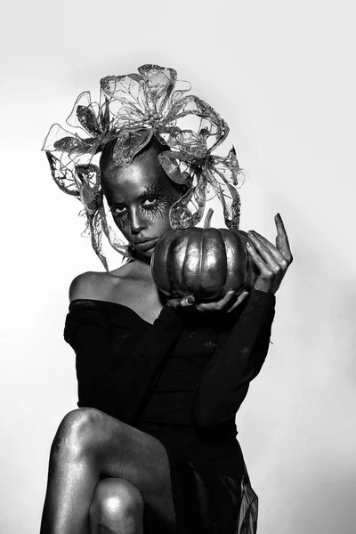 Golden woman with halloween pumpkin — Stock Photo, Image