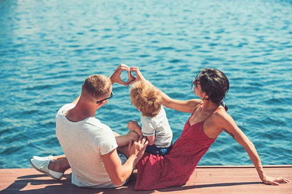Forma de coração de mãos pela família feliz em férias de verão. coração de amor no mar — Fotografia de Stock