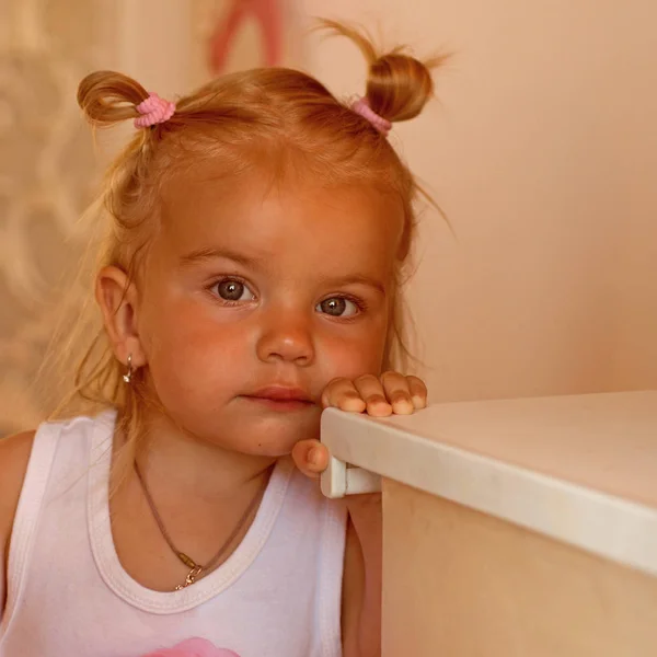 La coiffure est magnifique. Le petit enfant porte une coiffure drôle. Petite fille avec des queues de chignon. Adorable enfant aux cheveux blonds. Coiffure de filles fantaisie. Salon de coiffure pour enfants. Elle est si mignonne. — Photo