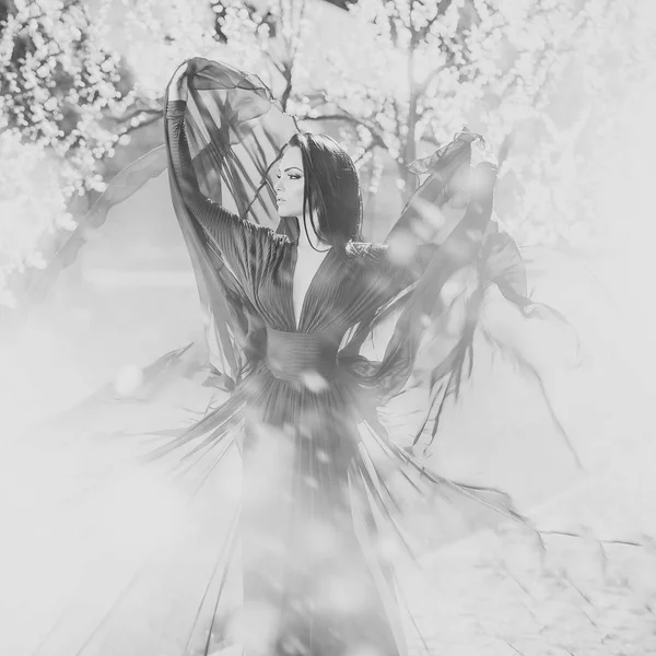 Jolie fille avec des pétales de fleurs tombant de l'arbre, beauté — Photo