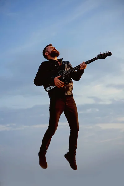 Music and freedom make him happy. Music, bearded hipster play guitar flying in blue sky — Stock Photo, Image
