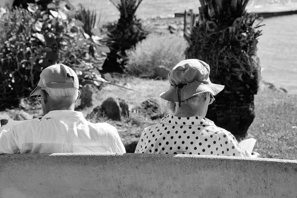 Senior mulher e homem ler livros sentados no banco do parque — Fotografia de Stock