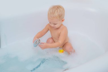 Küvet kabarık sabun köpüğü ile küçük çocuk. Kabarcık banyo zamanı. Küçük çocuk yıkanmasında içinde banyo. Çocuklar hijyen ve sağlık.