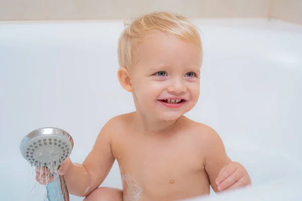 Gyerekek élménymedence. Fürdő. Boldog gyermekkor. Higiéniai és kisgyermekek gondozása. Mosolyogva, miközben veszi a fürdő fürdőszoba aranyos kisfiú. — Stock Fotó