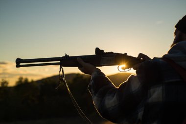 Silah varil. Tüfek Hunter içinde güzel gün batımı kontrast. Avcı hayvanlar lekelenme kapsamlı güçlü tüfekle. Metin için yer kopyalayın.