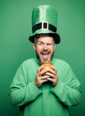 Altın pot ile mutlu St Patricks Günü kavramı. Adam yeşil zemin üzerine St Patricks Günü kutlamak. Patricks Günü Pot of Gold ve yoncaları.