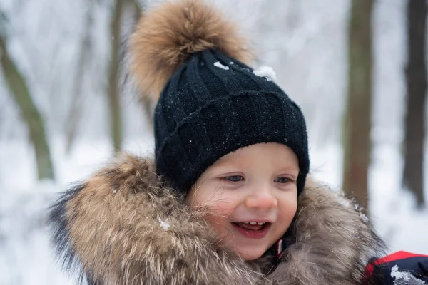 Glückliches Winterkind. Netter Junge im Winter. Winterferienkonzept. Schneefall. — Stockfoto