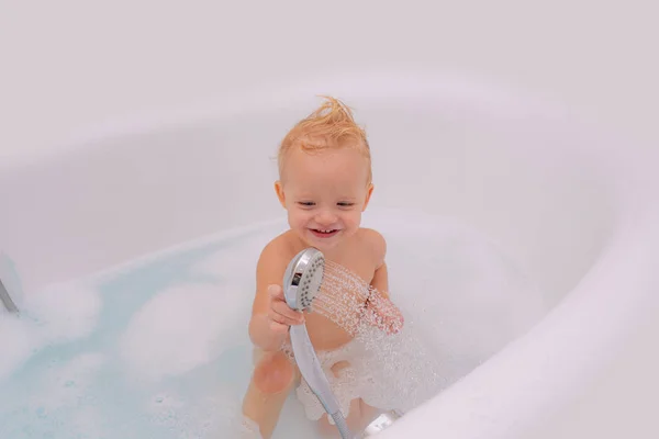 Mosolygós gyerek a fürdőszobában játékkacsával. Egy kisgyerek fürdik a fürdőszobában. Fehér alapon elszigetelve, vágási útvonallal. — Stock Fotó