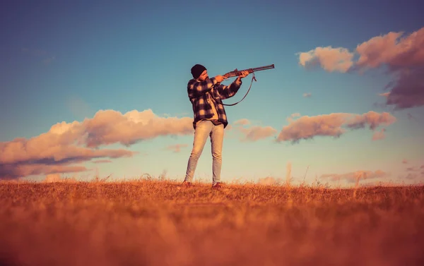 A vadászat puska kaliber. Puska-vadász rajzolódott ki, a gyönyörű naplemente. Őszi vadászidény. Nagy teljesítményű puska hatókörű pecsételő állatok Hunter. — Stock Fotó