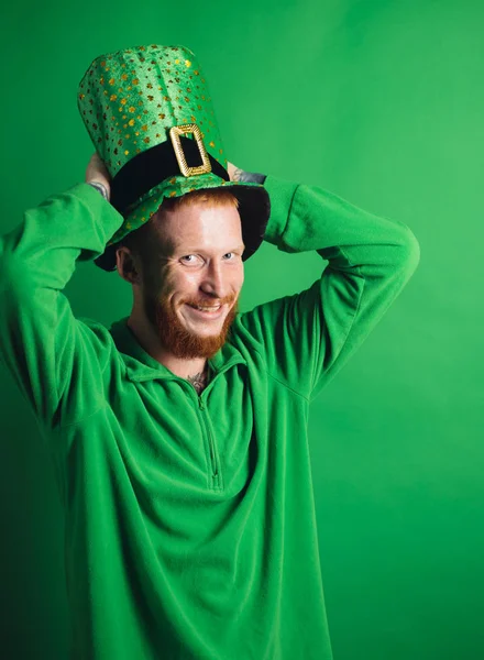 Γούρια σε πράσινο φόντο. Ο άνθρωπος σε πράσινο φόντο γιορτάζουν την ημέρα του Αγίου Πατρικίου. Ο άνθρωπος στο κοστούμι Patricks χαμογελώντας. — Φωτογραφία Αρχείου