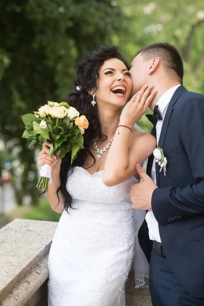 Woman and man smile on wedding day. Groom kiss happy bride with bouquet. Wedding couple in love. Newlywed couple on summer outdoor. Marriage concept. love and family — Stock Photo, Image