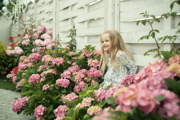 Childrens day. Small baby girl. Summer. Mothers or womens day. New life concept. Spring holiday. Little girl at blooming flower. Spring flowers. Childhood. happy girl. Spring in pot — Φωτογραφία Αρχείου