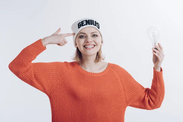 I was born genius. Happy woman hold light bulb pointing at head. Girl genius got bright idea. Sensual woman wear hat with genius word. A genius idea came into her head