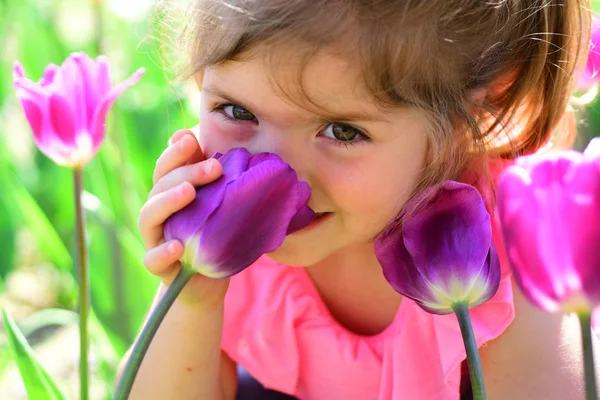 Gezicht huidverzorging. allergie voor bloemen. Lente tulpen. weersverwachting. Zomer meisje mode. Gelukkige jeugd. Klein meisje in het zonnige voorjaar. Klein kind. Natuurlijke schoonheid. Childrens dag. Genieten van de lente — Stockfoto