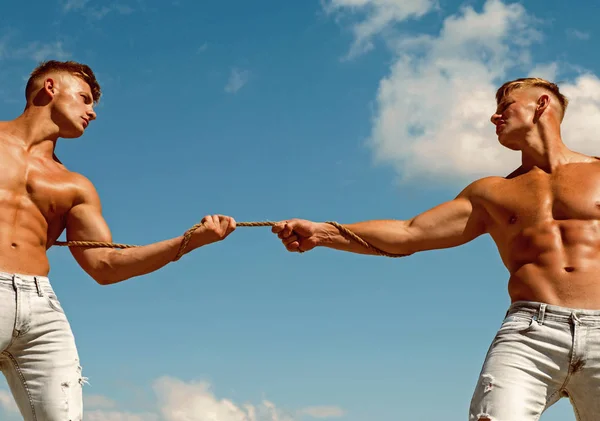 感力。強い人は、筋肉のハンドの強さとロープを引き出します。男性は競争相手に対して彼らの強さを示しています。反対側に運動の双子。筋肉の体と双子の競合 — ストック写真
