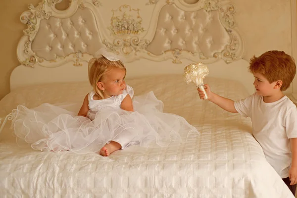 Crea un capello alla moda. La ragazzina dei fiori indossa la tiara dei capelli. Page boy con acconciatura bionda tenere mazzo di nozze. Sviluppo dei bambini. Bambini pronti per la cerimonia nuziale. Bella acconciatura — Foto Stock