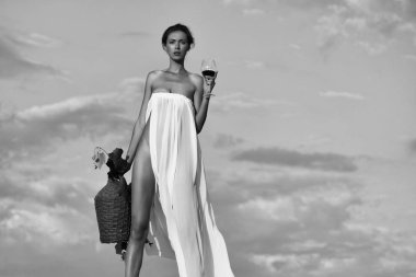 Gökyüzünde şarap şişesi olan güzel kız.