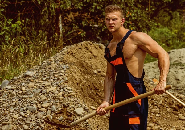 Concept de travailleur. Travailleur enlever le sol avec la pelle. Ouvrier en uniforme de travail. Travailleur fort avec le corps musculaire — Photo