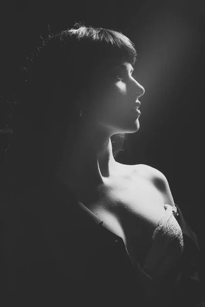 Κορίτσι με αισθησιακό πρόσωπο, γυμνό ώμο, ντεκολτέ σε σκοτεινό δωμάτιο. — Φωτογραφία Αρχείου