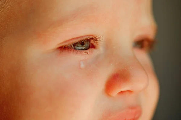 Pequena e infeliz. Bebé. Bebê com lágrimas rolando pela bochecha abaixo. Criança com cara triste. Ele é um bebé chorão. — Fotografia de Stock