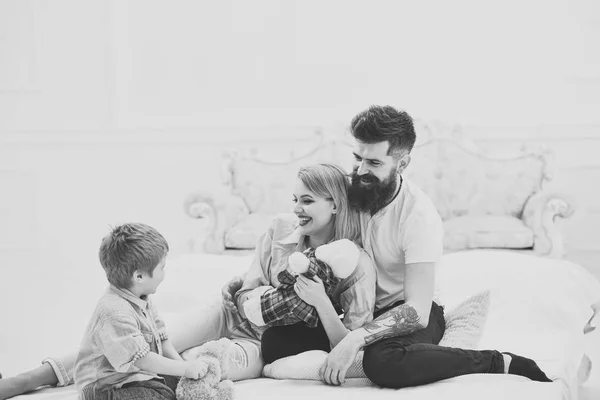 Γονείς Δώστε προσοχή στο παιδί. Μητέρα και ο πατέρας αγκαλιάς ακούοντας χαριτωμένο μικρό γιο τους. Ευτυχισμένη οικογένεια έννοια. Νεαρή οικογένεια περνούν χρόνο μαζί στην κρεβατοκάμαρα στο κρεβάτι, πολυτελές εσωτερικό υπόβαθρο. — Φωτογραφία Αρχείου