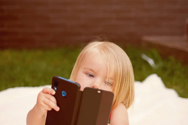 Je te vois. Nouvelles technologies pour les enfants. Petit enfant faire un appel vidéo avec smartphone. Petite fille avec téléphone portable. Enfant fille aux cheveux blonds parler sur téléphone portable. Soins capillaires naturels — Photo