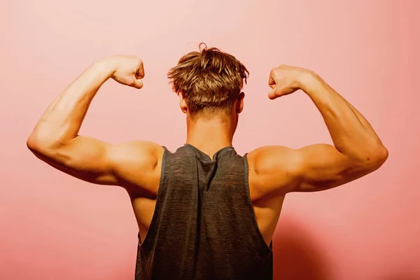 Koncepcja biceps. Sportowiec Pokaż biceps i triceps, widok z tyłu. Człowiek flex broni z biceps. Biceps mięśnie ramion — Zdjęcie stockowe
