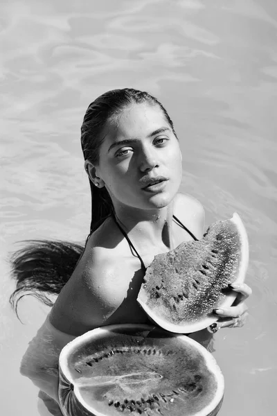 woman with watermelon in swimming pool
