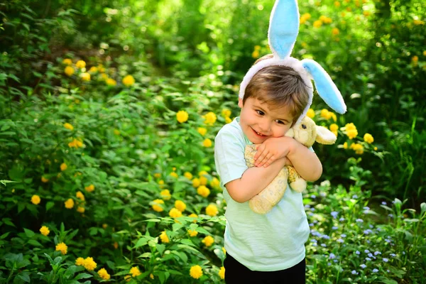Králík kluk s uši. Hračka zajíc. Vajíčka na jarní dovolenou. láska Velikonoce. Rodinná dovolená. Malý chlapec v zeleném lese. Veselé velikonoce. Dětství. Velikonoční vibrace — Stock fotografie