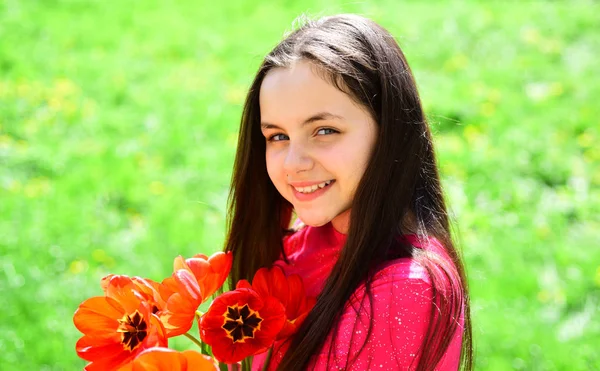 Flores como presente. Menina com flor bulbos florescer. Menina bonito criança com flores de tulipa vermelha no dia de primavera. Menina bonita com buquê de flores. Floração na primavera. Celebrando 8 de março ou dia das mulheres — Fotografia de Stock