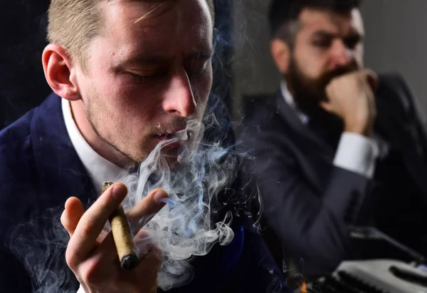 Thinking about problem solution. Thoughtful man smoking cigar. Businessmen hold business meeting. Business partners thinking together in office. Coworkers solving a business problem