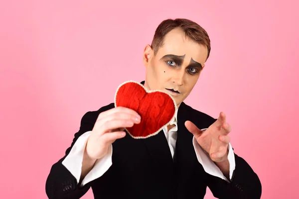 He is sensitive and very poetic. Mime man hold red heart for valentines day. Theatre actor pantomime falling in love. Mime actor with love symbol. Love confession on valentines day