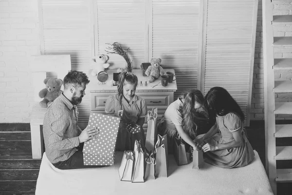 Familia con caras alegres regalos abiertos en casa — Foto de Stock