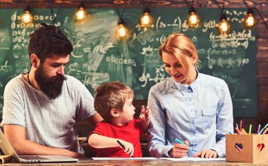 Keçeli kalem kağıt üzerinde aile boya. Anne ve baba ile oğlu masa başında oturmak. Kadın ve adam boyama küçük çocuk çalışma. Çizim birlikte keyfini çıkarın. Yaratıcılık ve geliştirme