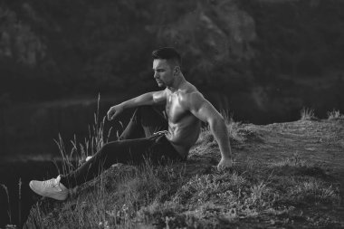 Genç maço erkek modeli atlet kaslı seksi vücut ve ıslak çıplak göğüs açık şehir manzarası ile tepe üzerinde