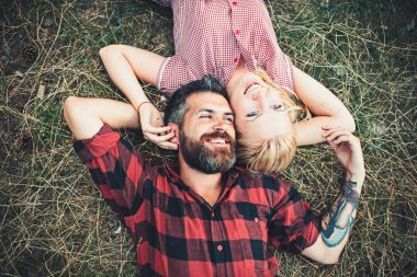 Aşık çift yeşil çimenlerin üzerinde rahatla. Aşık çift doğa yaz günü tadını çıkarın..