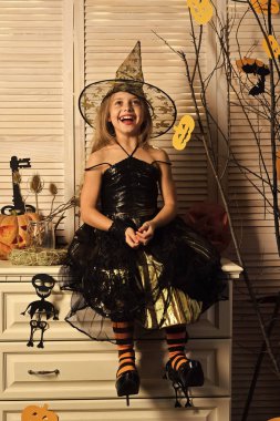 Çocuk cadı şapka ve komodinin üzerinde kostüm