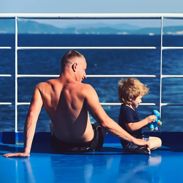 Padre con figlio in mare su yacht. La famiglia viaggia con il bambino il giorno dei padri. Amore e fiducia come valori familiari. Bambino con padre in gita in barca. Vacanze estive di famiglia felice . — Foto Stock