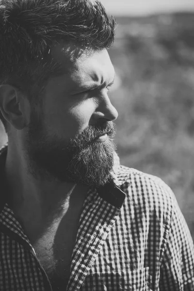 Hombre con barba y bigote sobre fondo de madera. El hombre con cara seria mira hacia otro lado soleado al aire libre . — Foto de Stock