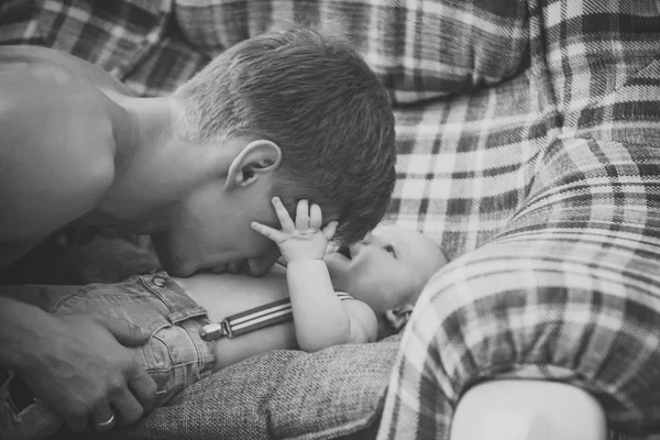 Padre jugar con bebé hijo en sofá —  Fotos de Stock