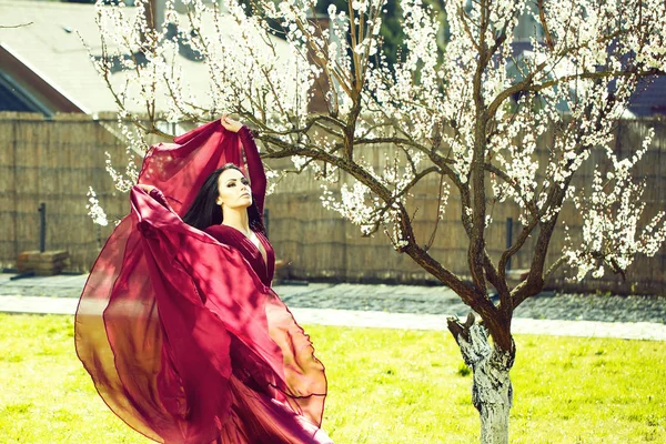 Mulher em vestido vermelho perto de flor — Fotografia de Stock