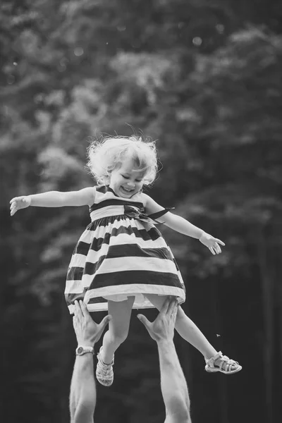 Menina sorriso voando para o pai mãos — Fotografia de Stock