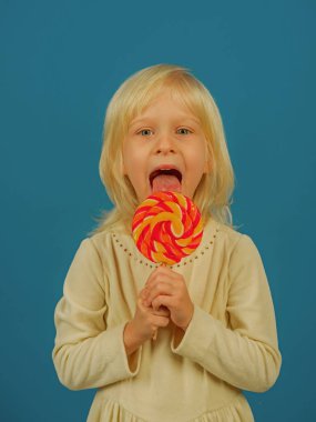 Heyecan yemek vakti için ekleme. Mutlu şeker kız. Küçük kız lolipop çubuğa tutun. Tatlı lolipop küçük çocuk. Mutlu çocukluk gıda