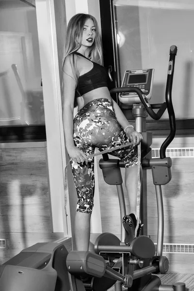 Mooi meisje op cross trainer — Stockfoto