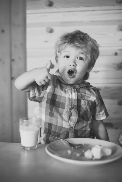 Enfant ou blond heureux garçon manger à table . — Photo